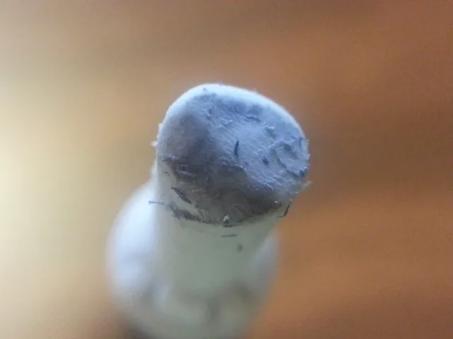 使い込まれた棒状消しゴムの先端。白い本体に対し、先端は灰色で細かいかすが付いている