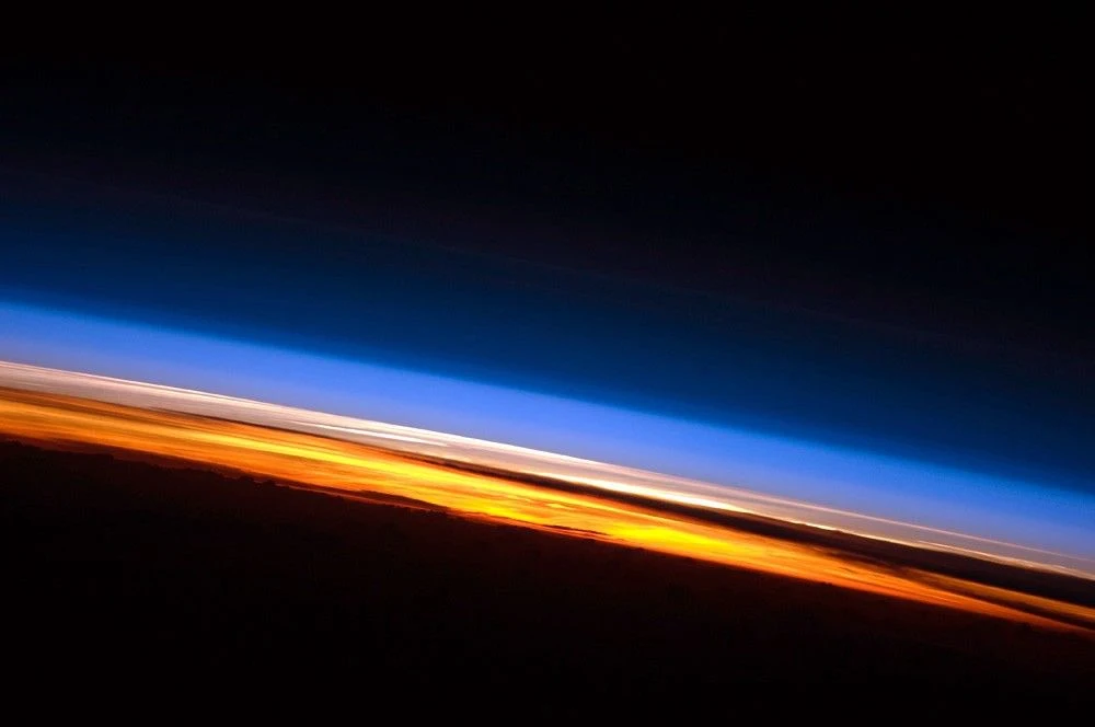 ISSから撮影された地球の縁。橙色の夕暮れの帯の上に青い大気が重なる