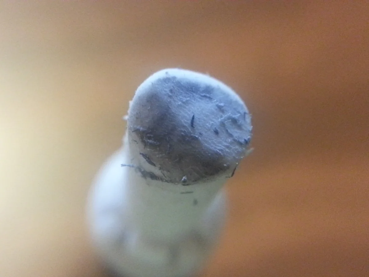 使い込まれた棒状消しゴムの先端。白い本体に対し、先端は灰色で細かいかすが付いている